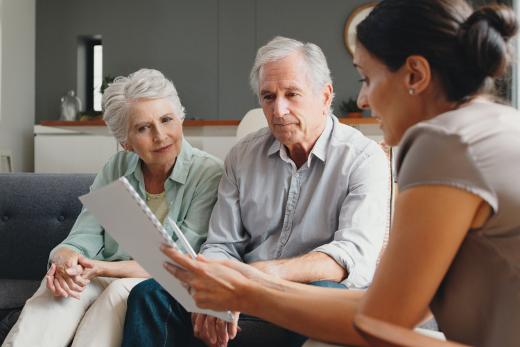 Elderly couple sat on couch talking to younger woman