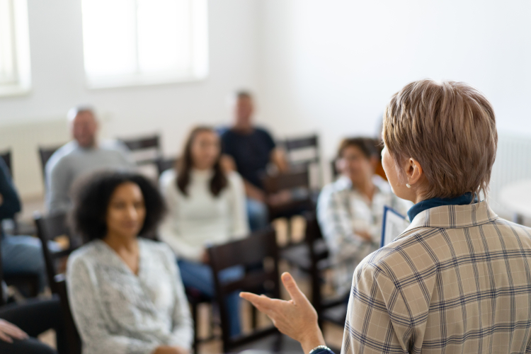 Lady presenting to a mixed crowd